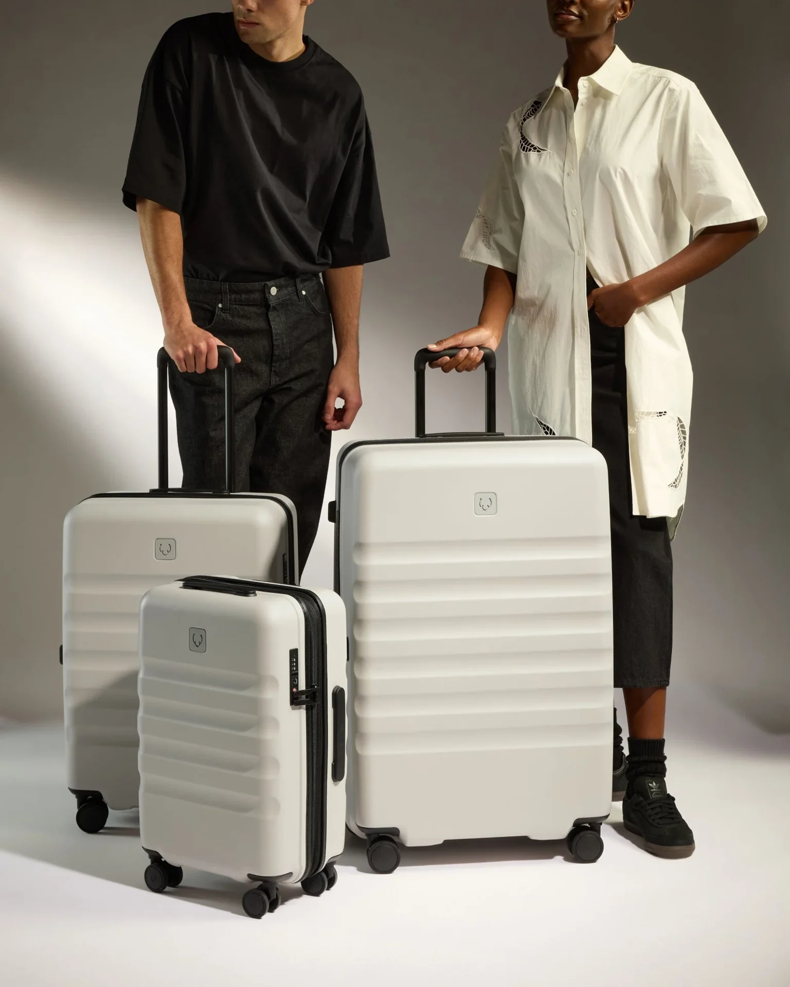 Models with white Antler luggage in a studio setting.