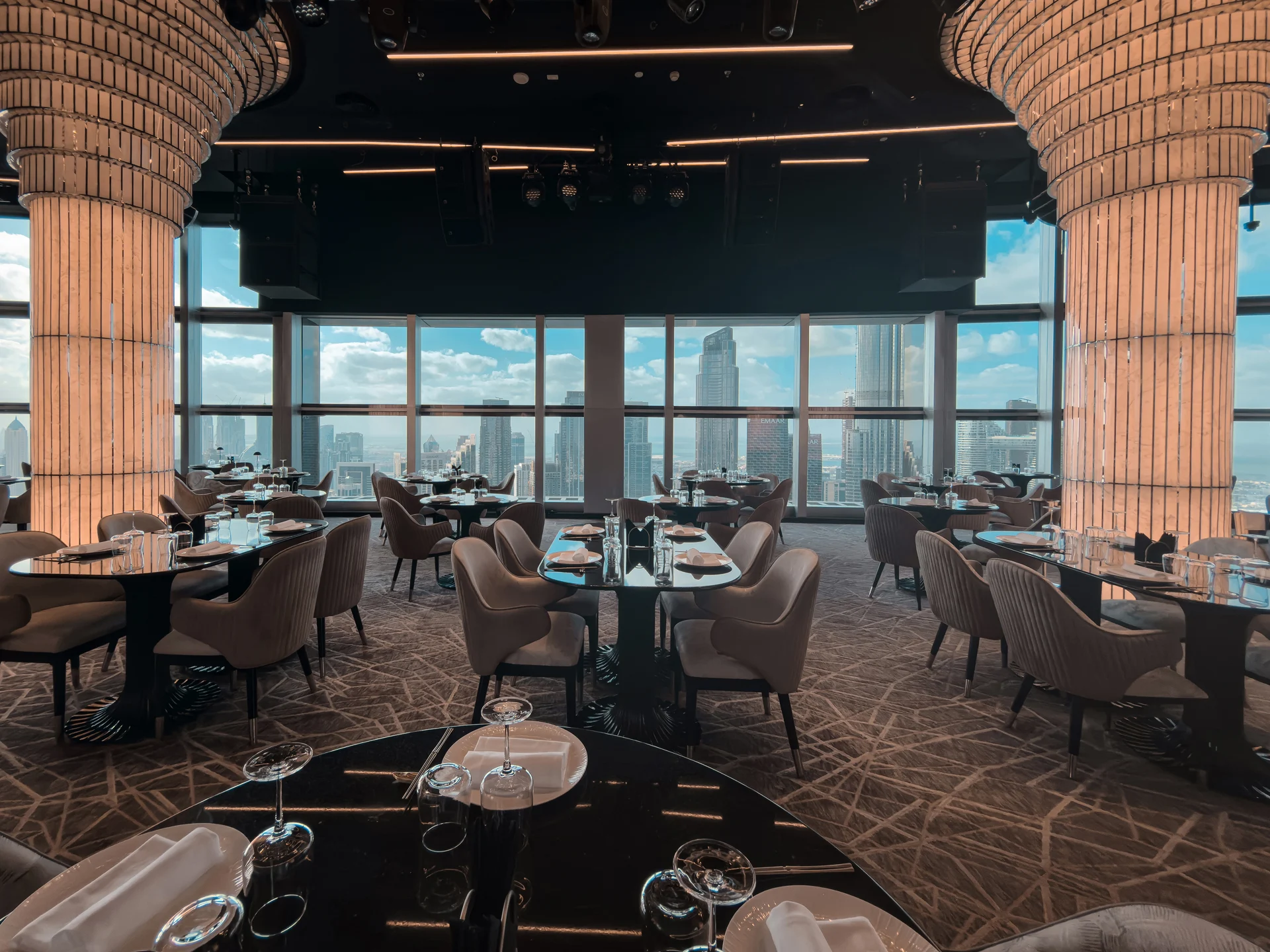 BIRDS Dubai dining table beside a skyline window.