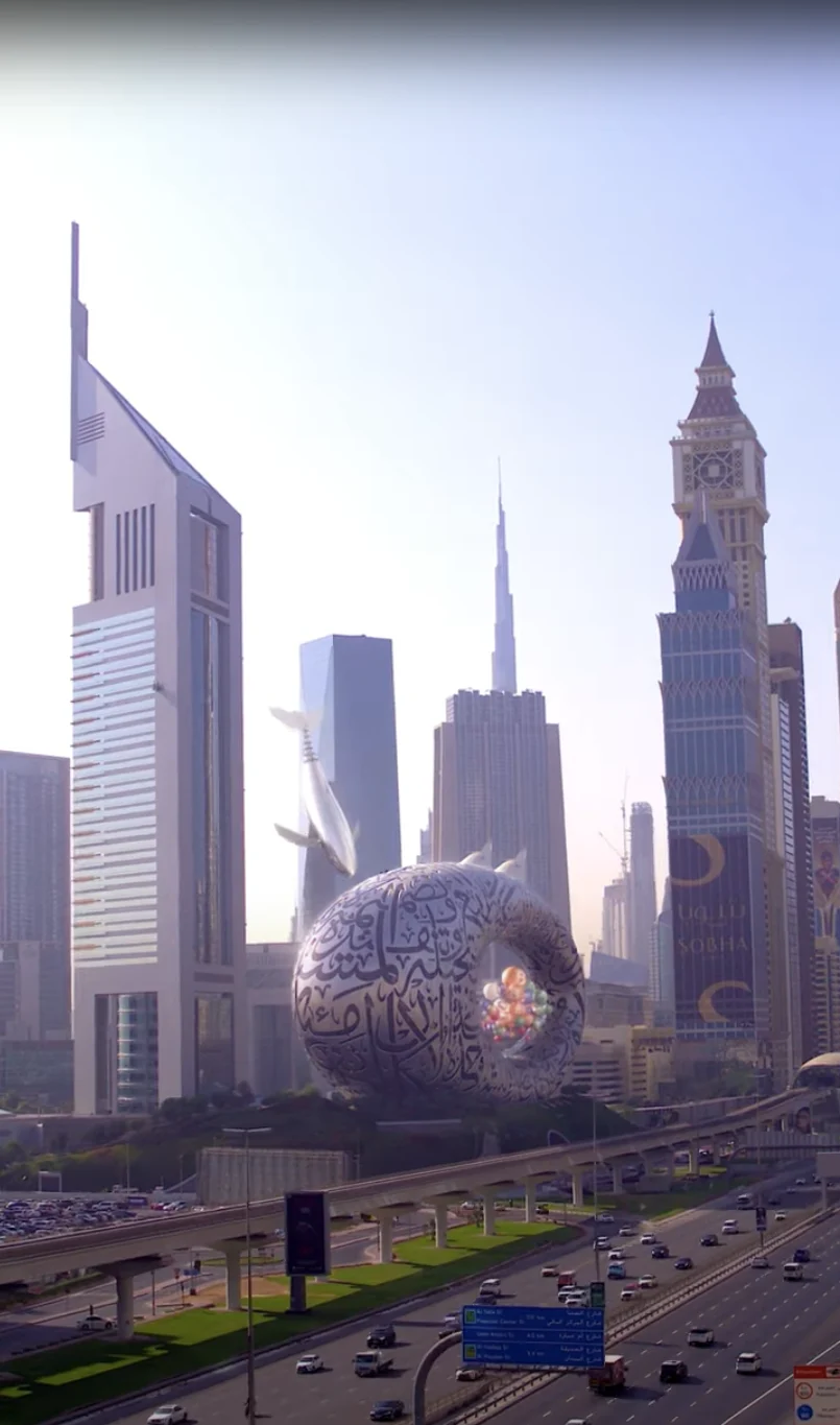 Metal whale gliding near Museum of the Future in Dubai skyline.