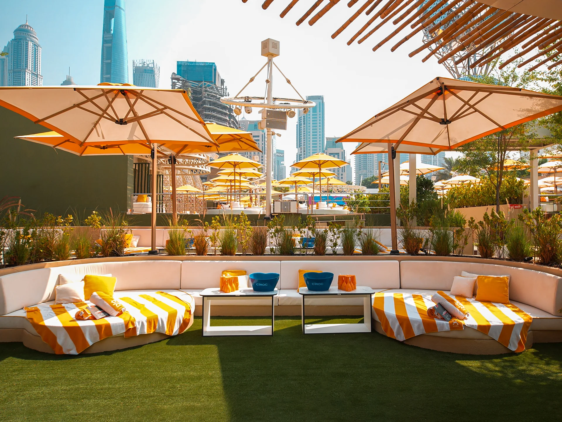 Private cushion lounge at O Beach Dubai with striped sunbeds and umbrellas.