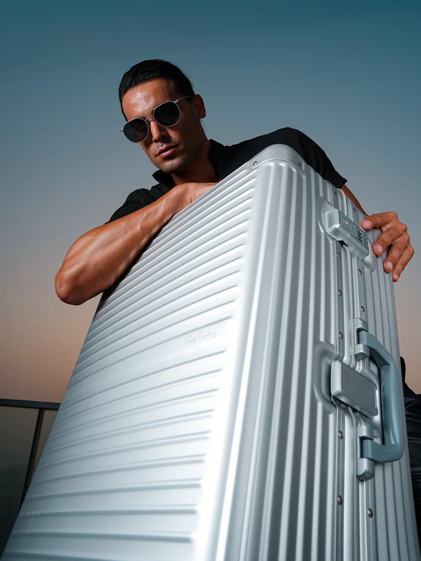 Model holding a silver Pierre Cardin Osaka suitcase.