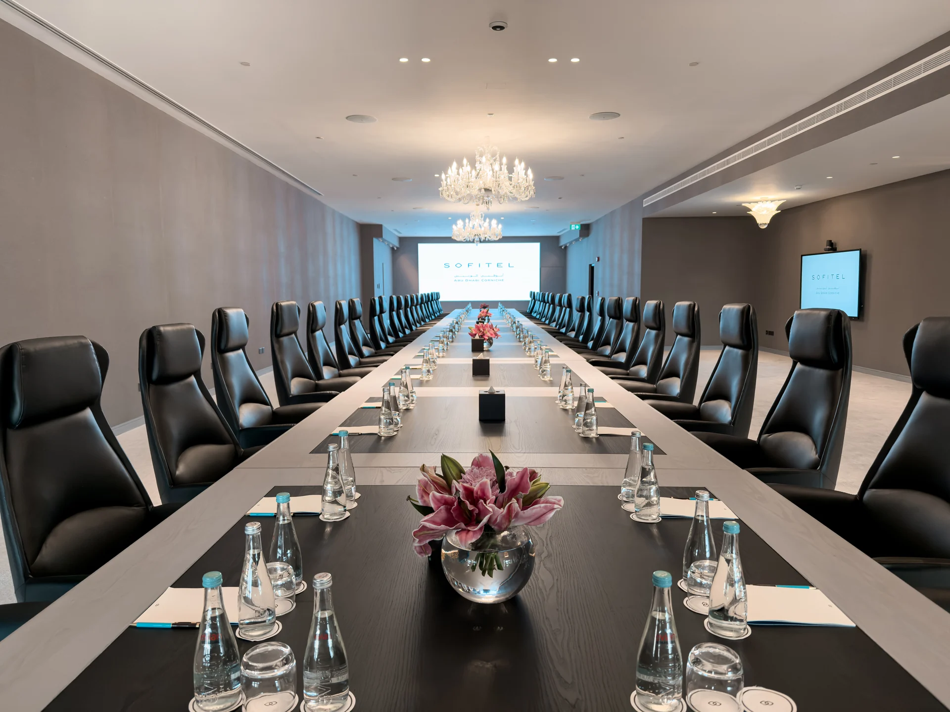 Executive boardroom at Sofitel Abu Dhabi Corniche with branded presentation screen.