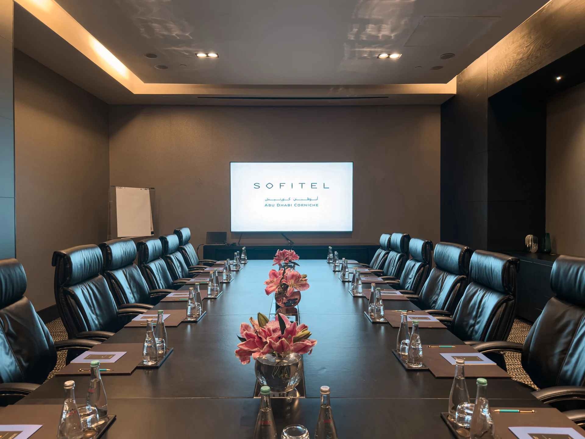 Executive boardroom at Sofitel Abu Dhabi Corniche with flower arrangement.